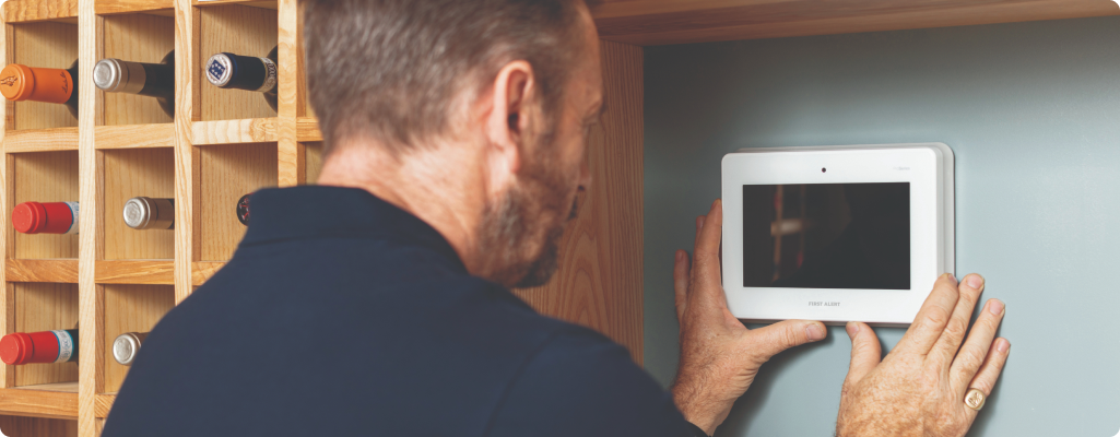 Man adjusting a security panel on a wall